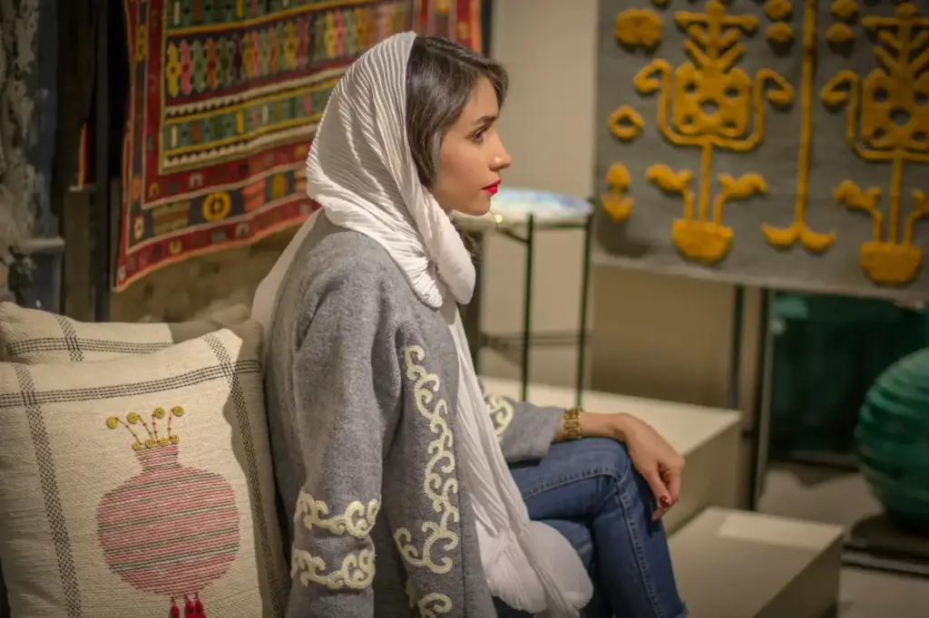 A woman wearing a white headscarf, grey long-sleeved jacket, and jeans — an example of appropriate modest clothing for visiting the Blue Mosque